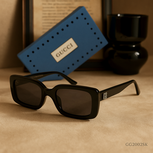 Black sunglasses on a beige surface with a Gucci wallet in the background